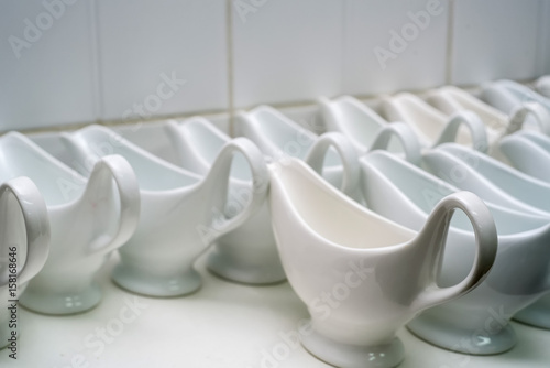Clean empty ceramic sauce boats in restaurant