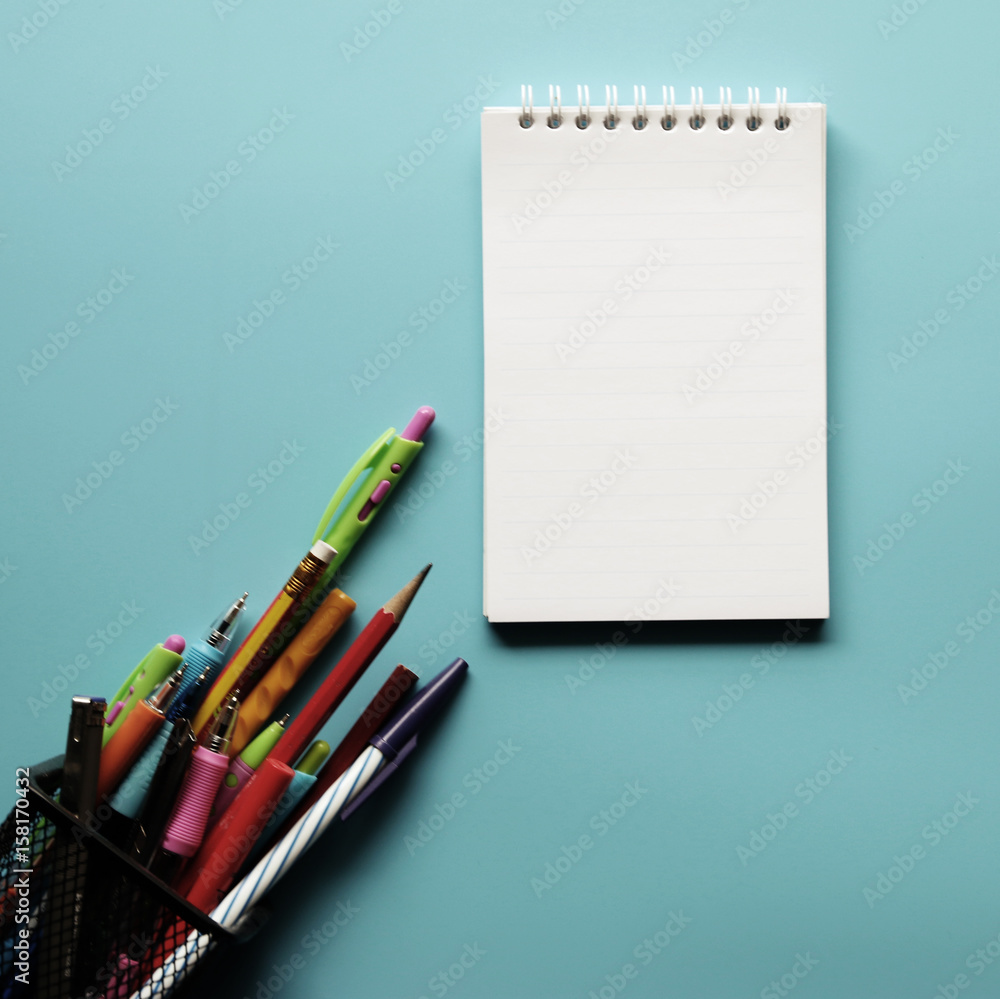 Creative workspace desk with notepaper,pencil in box on blue background ,copy space, minimal style Creative workspace desk with notepaper,pencil in box on blue background ,copy space, minimal style