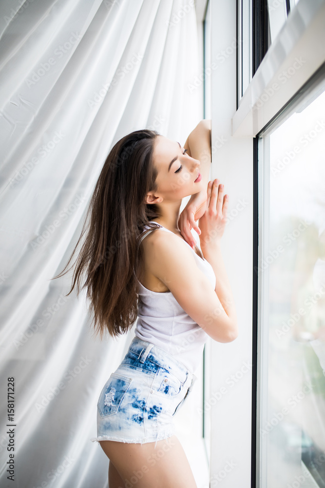 close up of happy woman opening window curtains in the morning