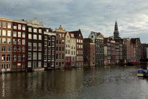 Beautiful panarama view of old Amsterdam buildings near the river under blue sky in dusk light