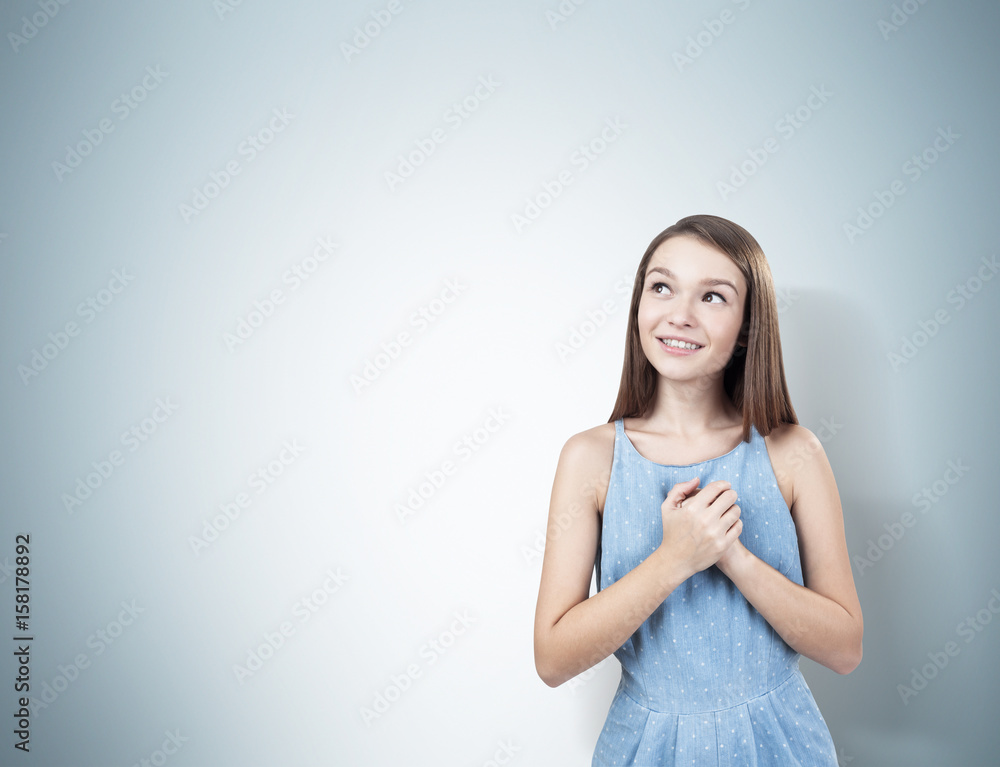 Dreamy teen girl with hands near heart Dreamy teen girl with hands near heart