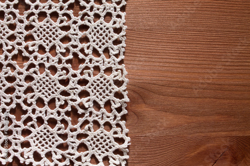 White crochet napkin on brown wooden background