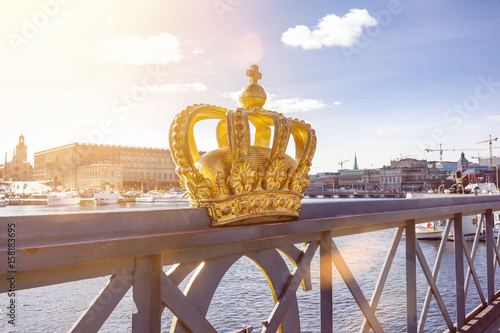 Skeppsholmsbron (Skeppsholm Bridge) with famous golden crown with royal palace in the background in Stockholm, Sweden
