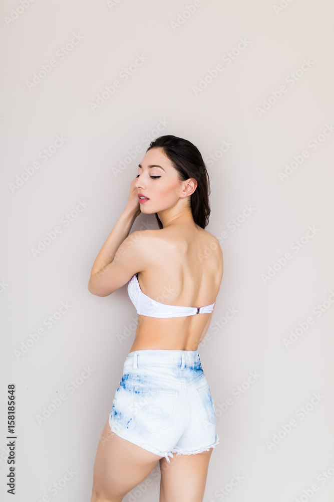 Fototapeta premium Beautiful woman wearing jeans shorts and bra isolated