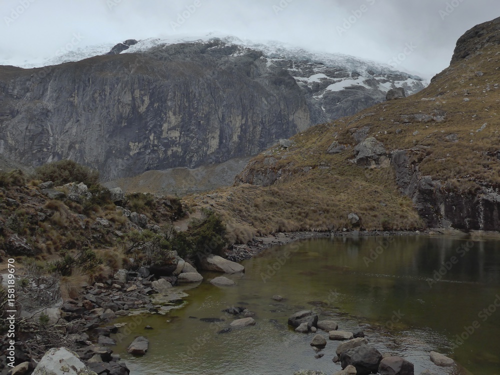 Cold shallow mountain lake on an overcast day amoung the majestic Peruvian Andes