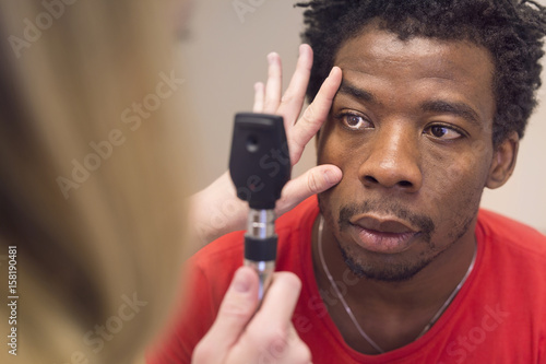 Doctor examining young man's eye