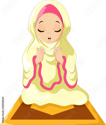Muslim girl sitting on the prayer rug while praying