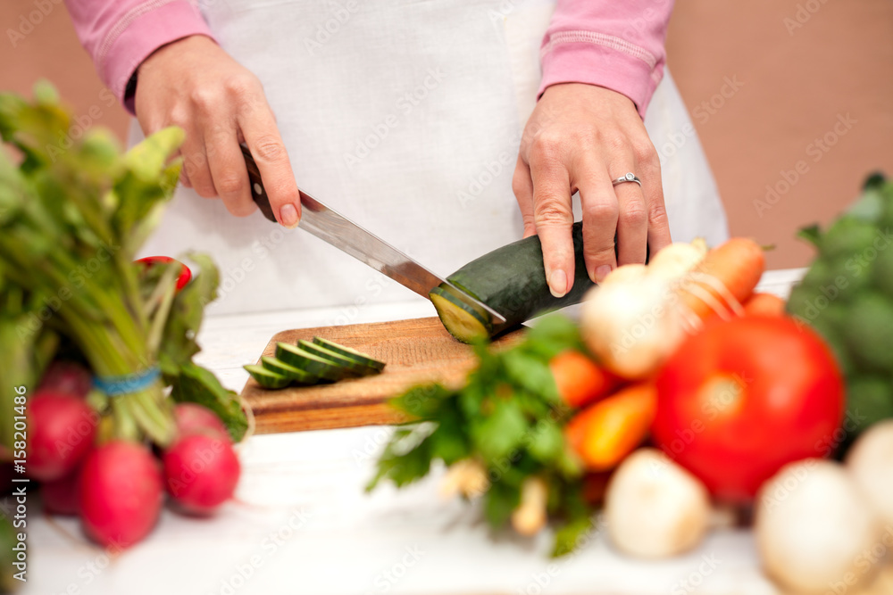 Woman cutting vegetables with a knife Woman cutting vegetables with a knife