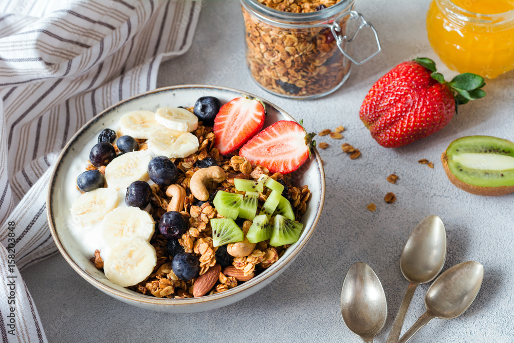 Granola, banana, strawberry, kiwi, blueberries and yogurt in bowl. Healthy breakfast oat cereals Granola, banana, strawberry, kiwi, blueberries and yogurt in bowl. Healthy breakfast oat cereals