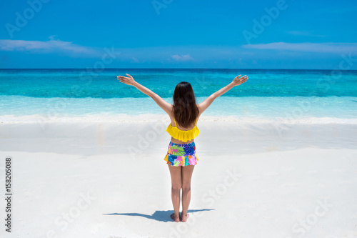 Beautiful bikini woman stand and enjoying tropical beach nature with white sand and blue sea at Andaman Similan island Phangnga Thailand. Travel vacation summer concept.