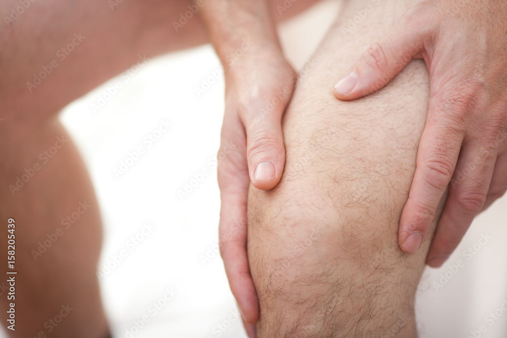 Man holding his knee Man holding his knee