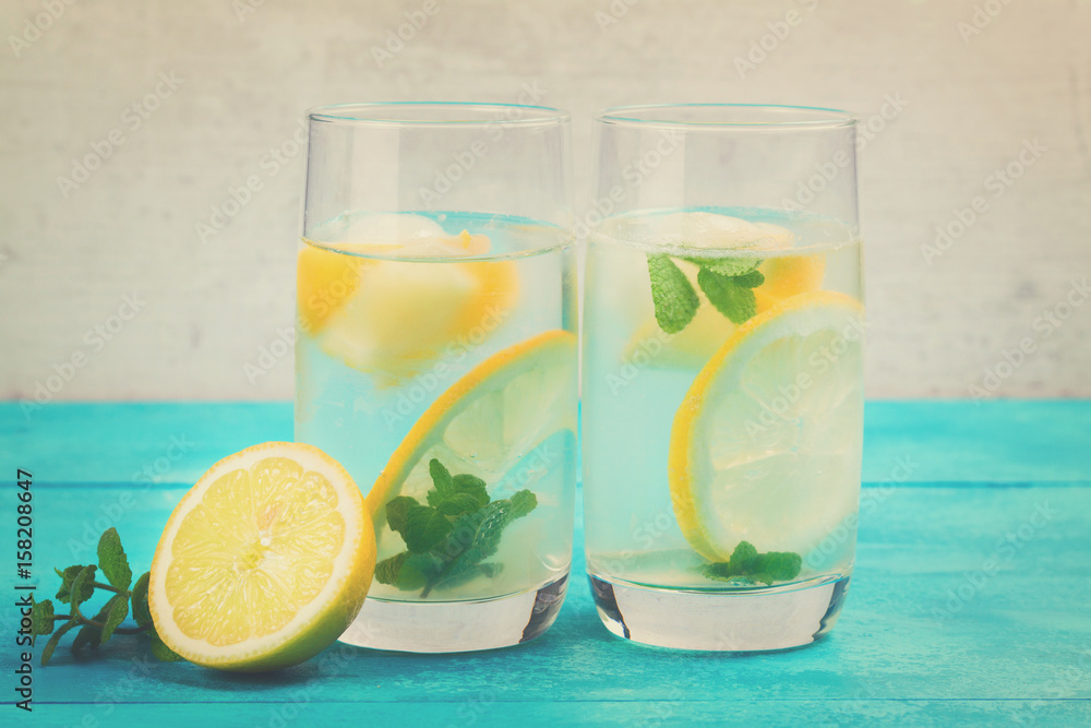 Lemonade homemade drink - two glasses with ice and mint, retro toned