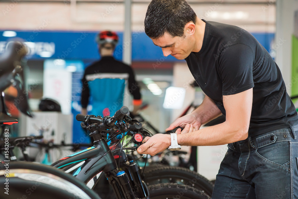 Male master is fixing the bicycle in a special workshop Male master is fixing the bicycle in a special workshop