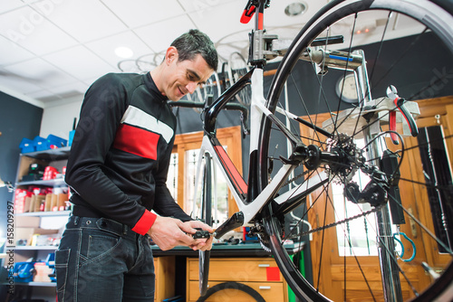 Male master is repairing the bicycle in a special workshop