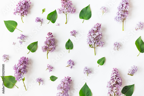 Fototapeta Naklejka Na Ścianę i Meble -  Flat lay top view photo of a pattern made of a lilac flowers, leaves and petals.