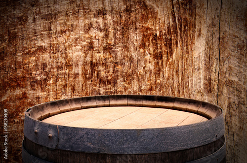 Image of old oak wine barrel in front of wooden background