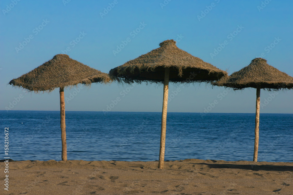 Straw umbrellas on a beautiful tropical beach