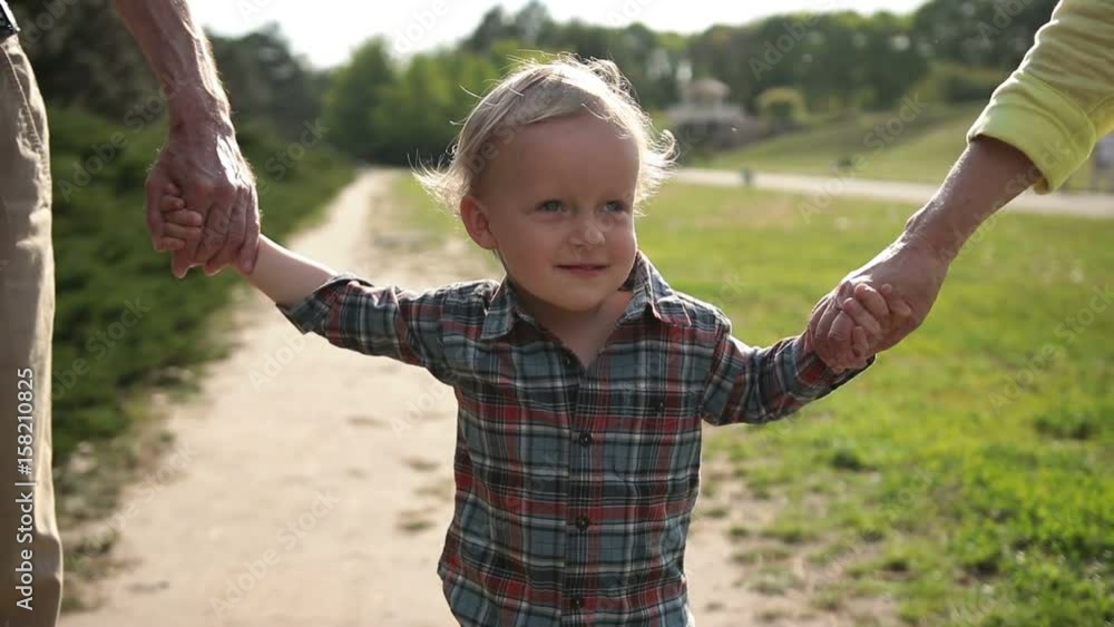 Excited boy walking with grandparents in park Excited boy walking with grandparents in park