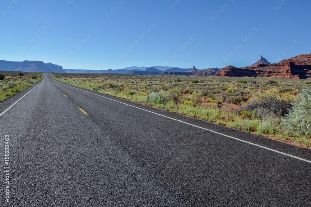 empty country road in grasslands with flat top mountains in the background
UT-211 Scenic Highway, Canyonlands National Park, Utah, United States