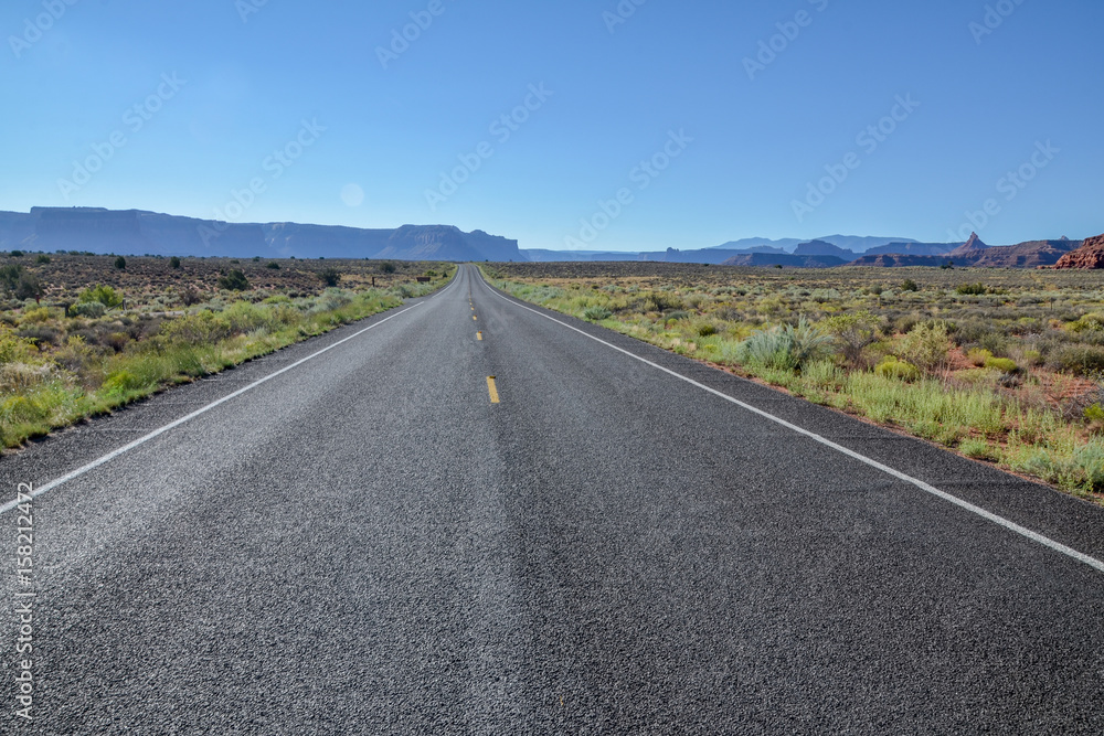 empty country road in grasslands with flat top mountains in the background
UT-211 Scenic Highway, Canyonlands National Park, Utah, United States