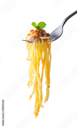 Spaghetti on a fork with tomato sauce and mint on white background