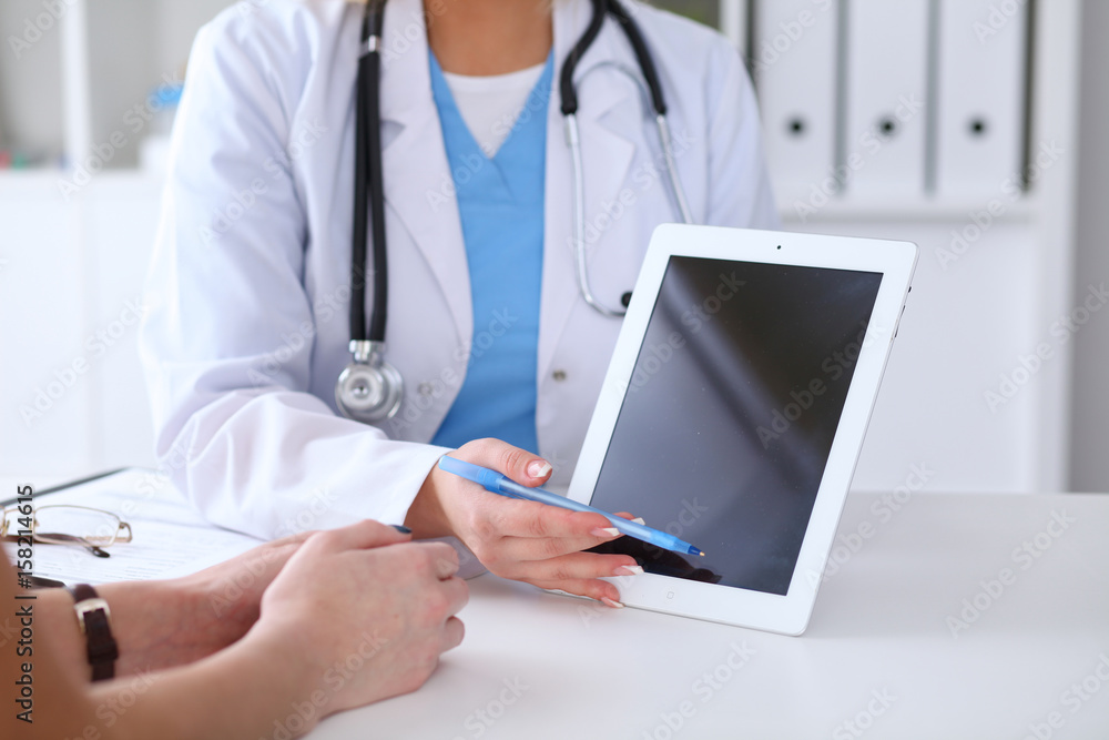Close up of a doctor and patient hands while phisician pointing into tablet computer monitor Close up of a doctor and patient hands while phisician pointing into tablet computer monitor