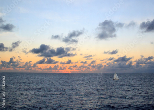 Sail boat on the ocean at sunrise