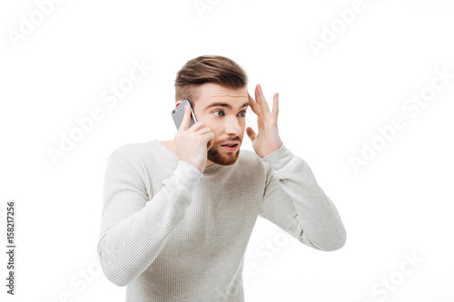 Young man missunderstanding and arguing talking on the phone isolated photo