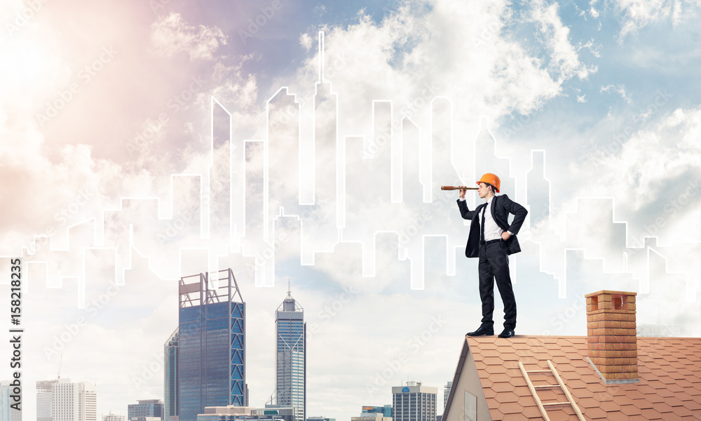 Engineer man standing on roof and looking in spyglass. Mixed med Engineer man standing on roof and looking in spyglass. Mixed med