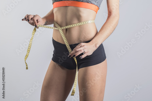 Mujer delgada con cinta métrica en la cintura