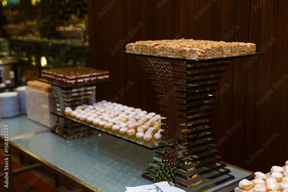 Selection of decorative desserts on a buffet table at a catered luxury event or celebration Selection of decorative desserts on a buffet table at a catered luxury event or celebration