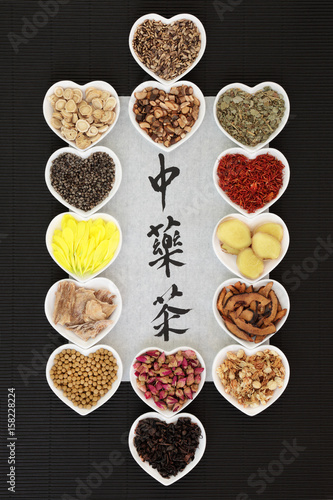 Traditional chinese herb tea selection with calligraphy on rice paper on black ridged paper background. Teas also used in natural alternative medicine. Translation reads as chinese herb tea.
