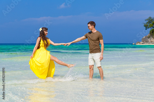 Couple having fun on tropical beach. Summer vacation concept.