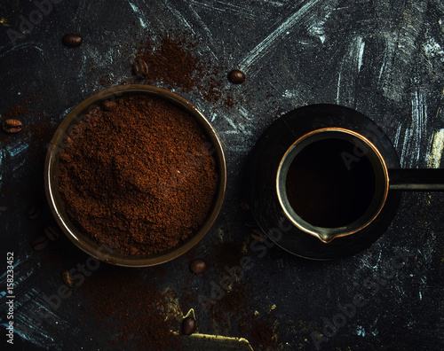 Ground coffee and coffee maker, dark background. Low key, top view