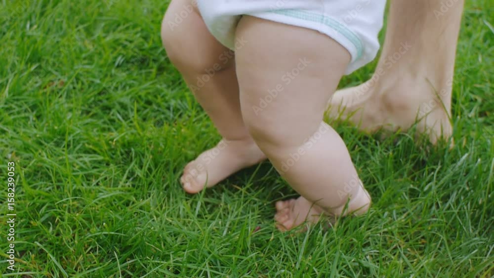 Father helps baby learning to walk Father helps baby learning to walk