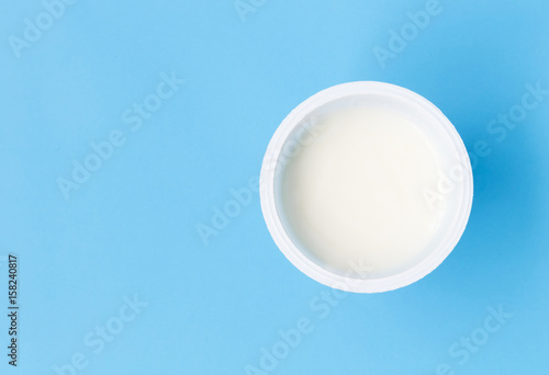 Closeup top view greek yogurt in white cup with blue background