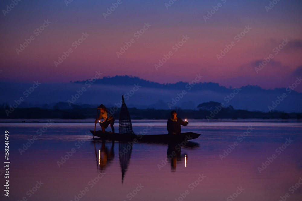 Silhouette fisherman are moveing to fishing on before sunrise,during sunrise,Thailand