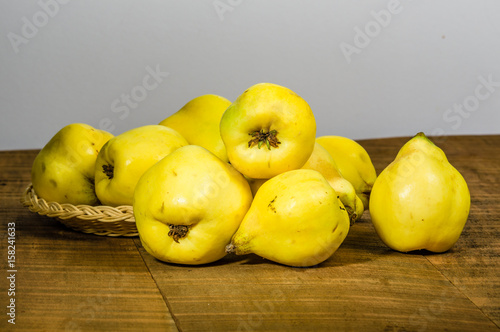 Ripe yellow quince fruit on wooden table