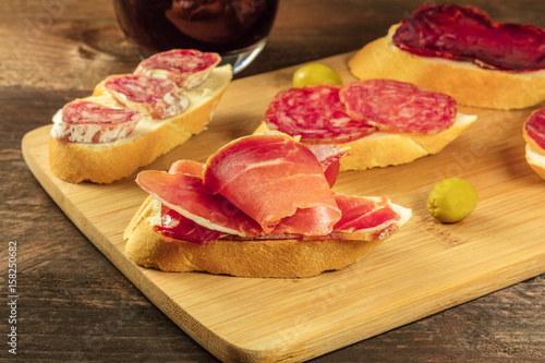 Spanish embutidos tapas, sandwiches with sausages, and wine photo