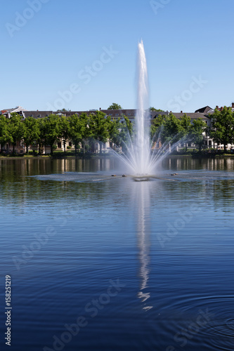 Fountain on the lake pfaffenteich in schwerin, the capital city of mecklenburg-vorpommern, germany, blue water with reflection and blue sky with copy space