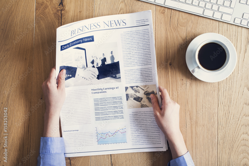 Naklejka premium Reading newspaper on desk