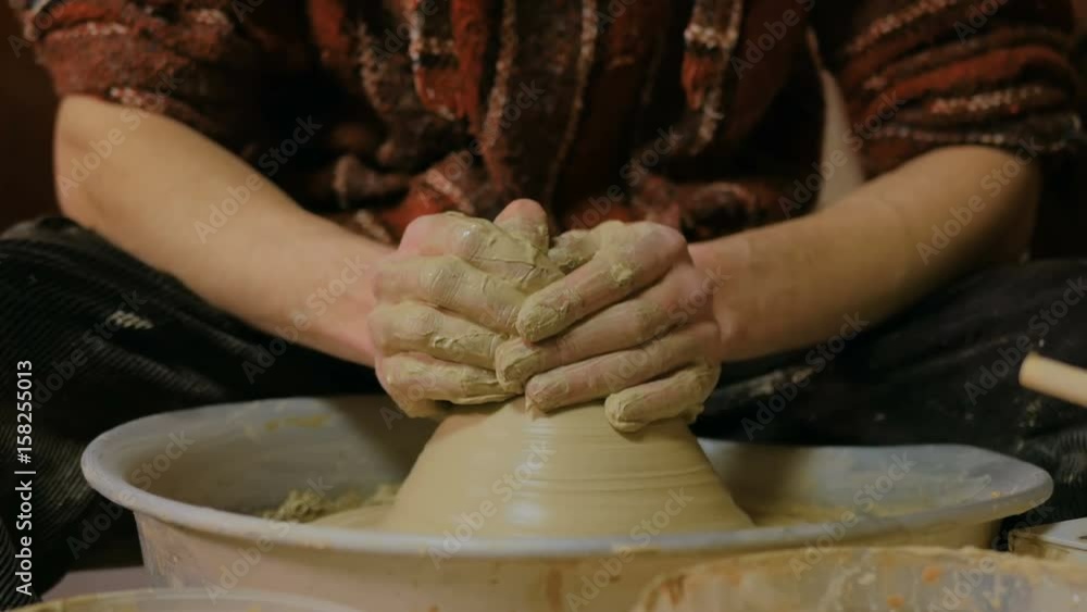 Professional male potter working with clay on potter's wheel in workshop, studio. Handmade, art and handicraft concept Professional male potter working with clay on potter's wheel in workshop, studio. Handmade, art and handicraft concept