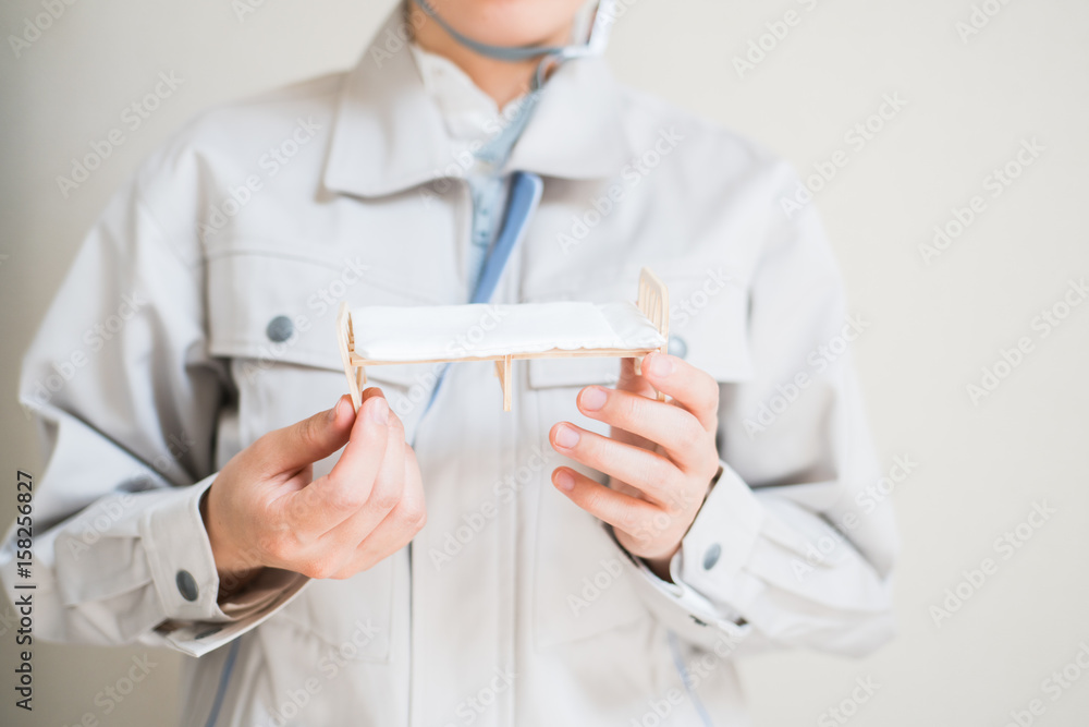 ベッドを持つ女性作業員 ベッドを持つ女性作業員