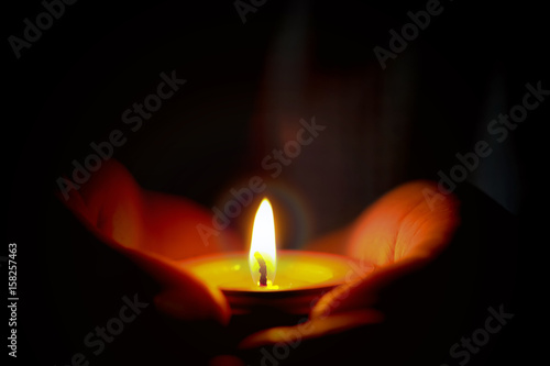 Prayer and hope concept of candle light in hands