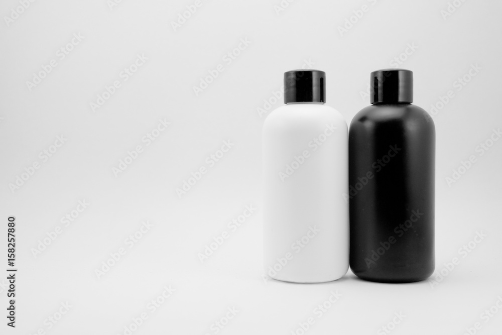 Black and white cosmetic skin care containers and charcoal raw soap package on white isolated background. Black and white cosmetic skin care containers and charcoal raw soap package on white isolated background.