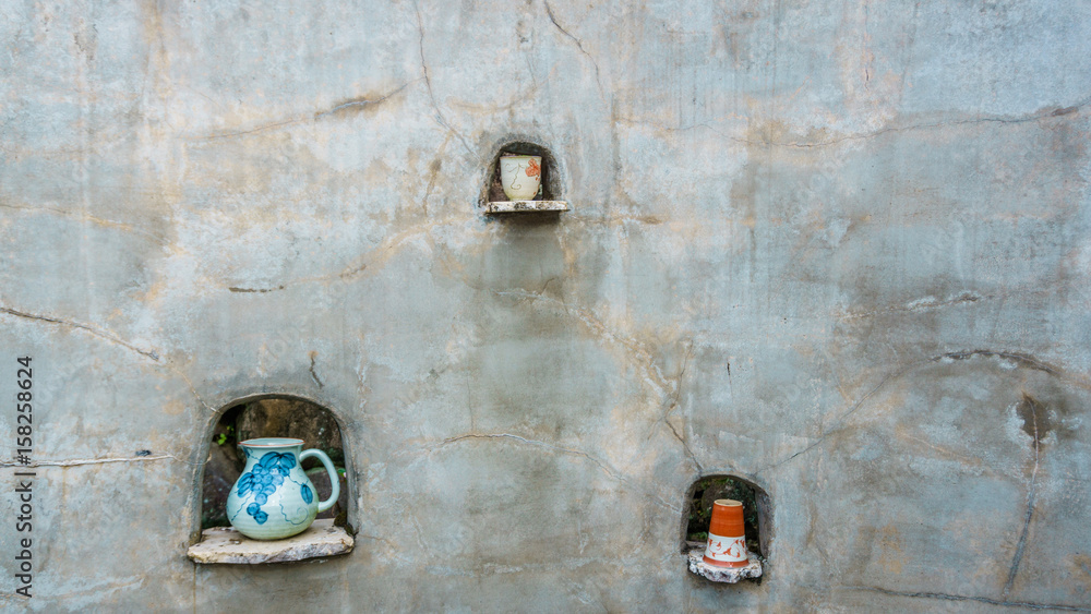 Pottery displayed on a rustic outdoor wall.