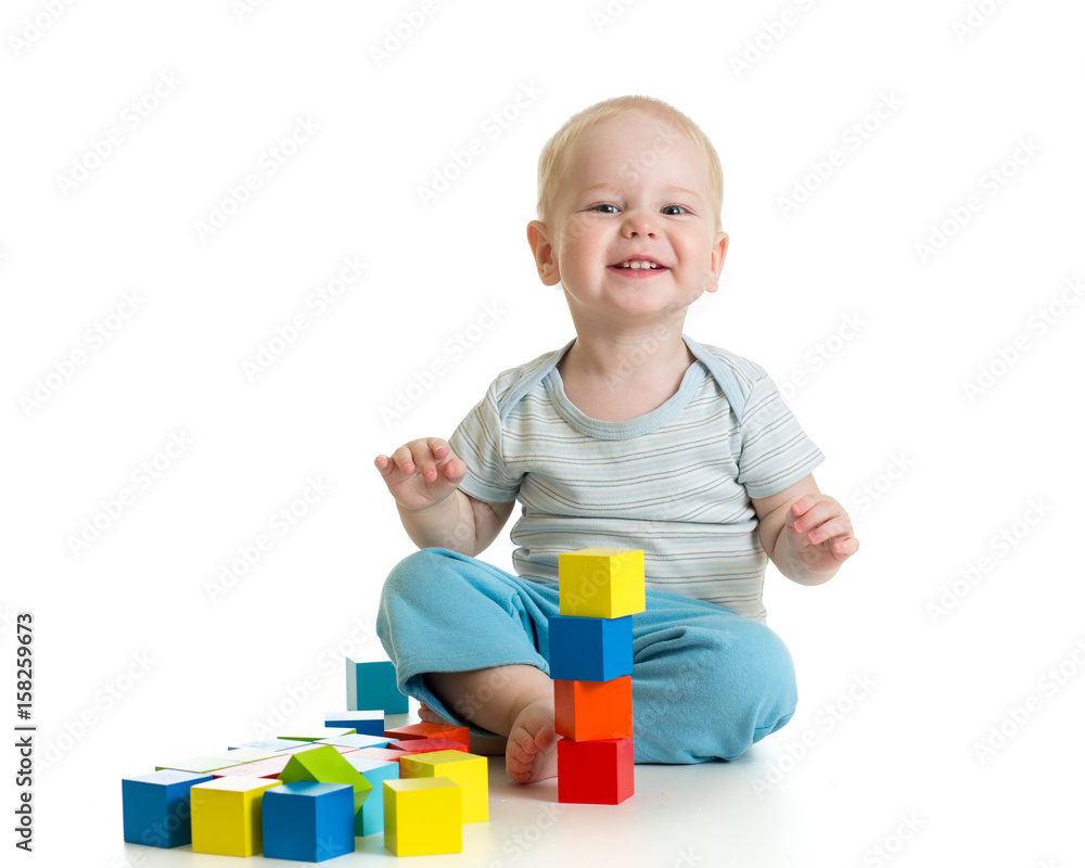 Funny child playing wooden toy blocks isolated on white Funny child playing wooden toy blocks isolated on white