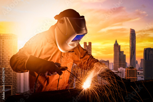 Industrial worker welding steel of construction structure for infrastructure architecture building project. photo