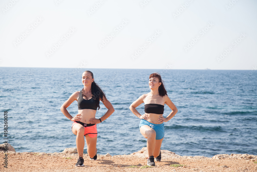 two girls play sports fitness on the beach two girls play sports fitness on the beach