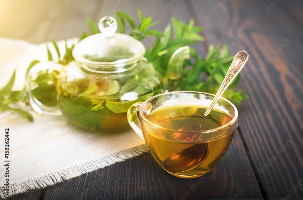 Cup of mint tea and a bunch of mint on the table. Cup of mint tea and a bunch of mint on the table.